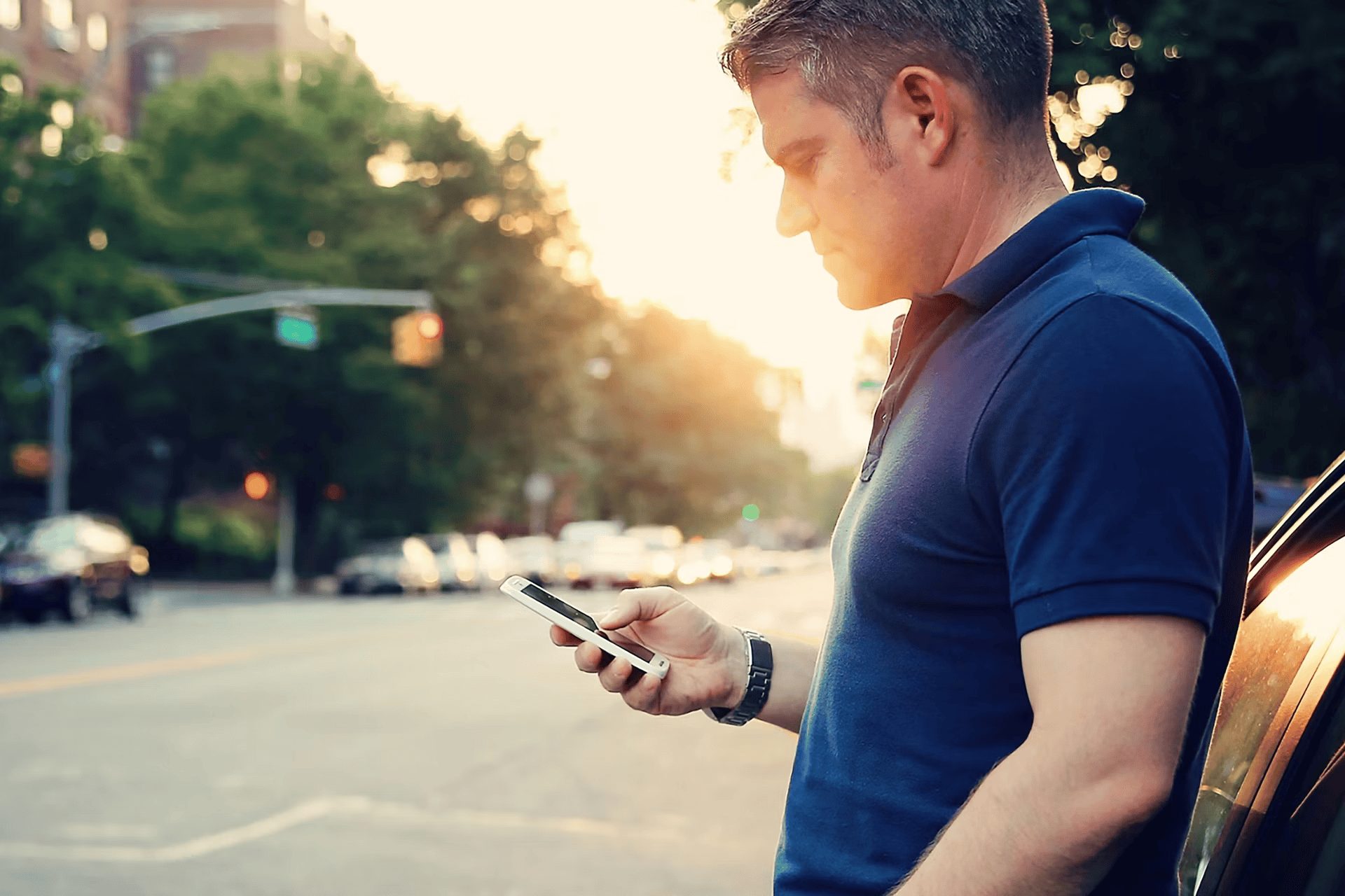 Young man using smartphone outdoors near a Ford car in Barrhaven.