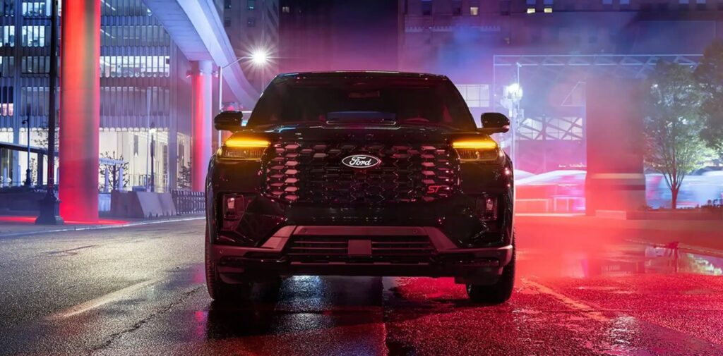 2027 Ford Explorer front view parked on a wet city street at night